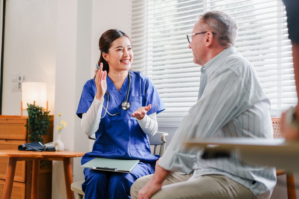 Smiling Licensed NP is visiting a patient