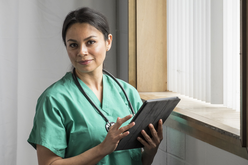 A nurse holding a tablet.